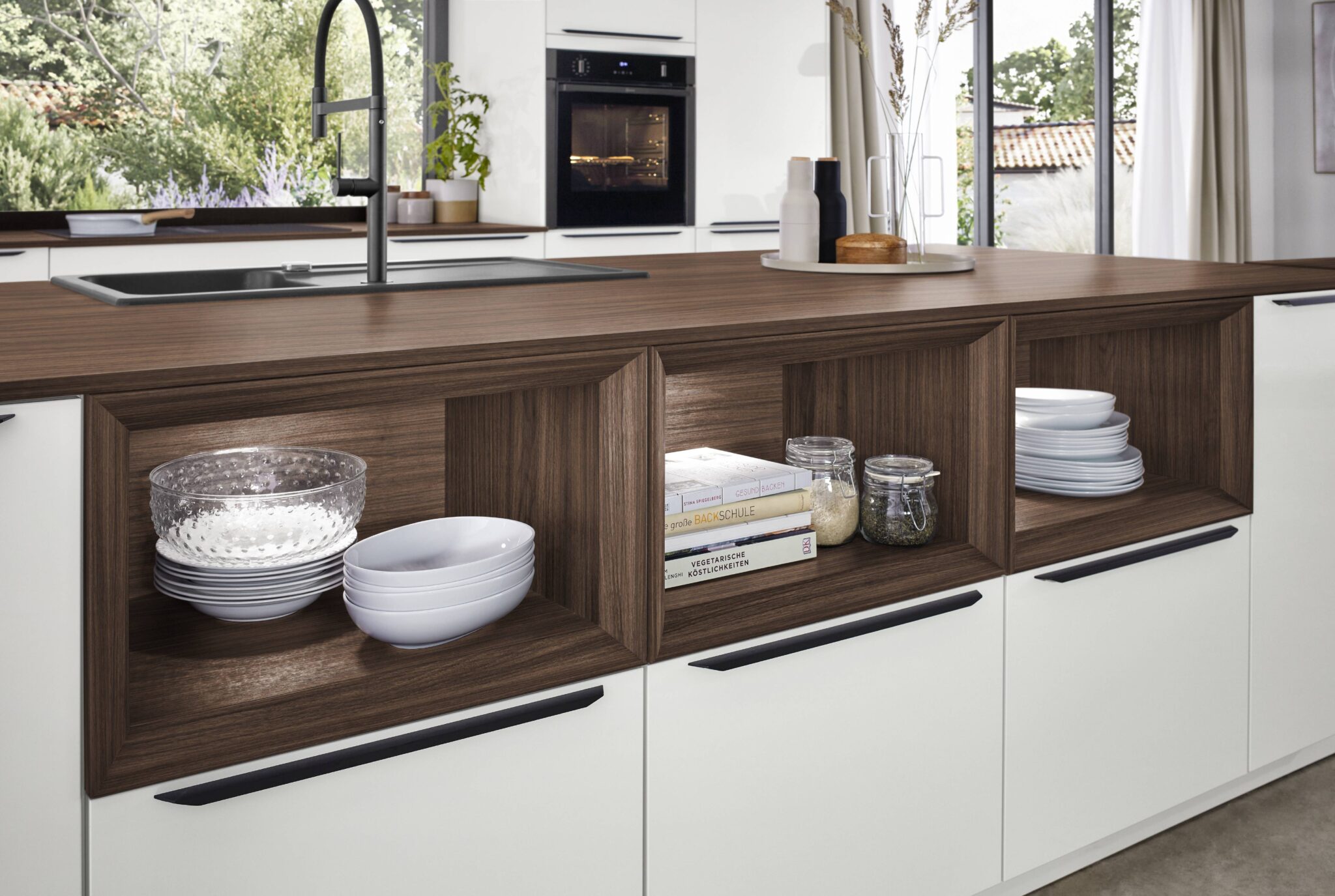 Des étagères en bois foncé avec vaisselle blanche, livres et bocaux en verre, intégrées dans une cuisine moderne avec plan de travail en bois.