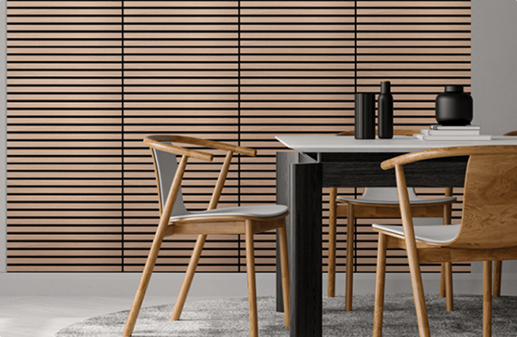 Chaises en bois clair autour d'une table noire sur un tapis gris, devant un mur à rayures horizontales en bois.