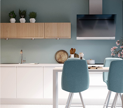 Cuisine moderne avec mur bleu, chaises hautes bleues, plan de travail blanc, armoires en bois clair, et hotte en acier inoxydable.