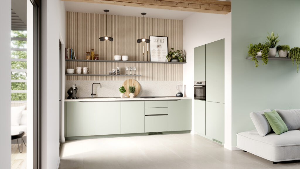 Cuisine moderne avec armoires vertes, étagères en bois, plan de travail clair et plantes décoratives, éclairée par des suspensions noires.